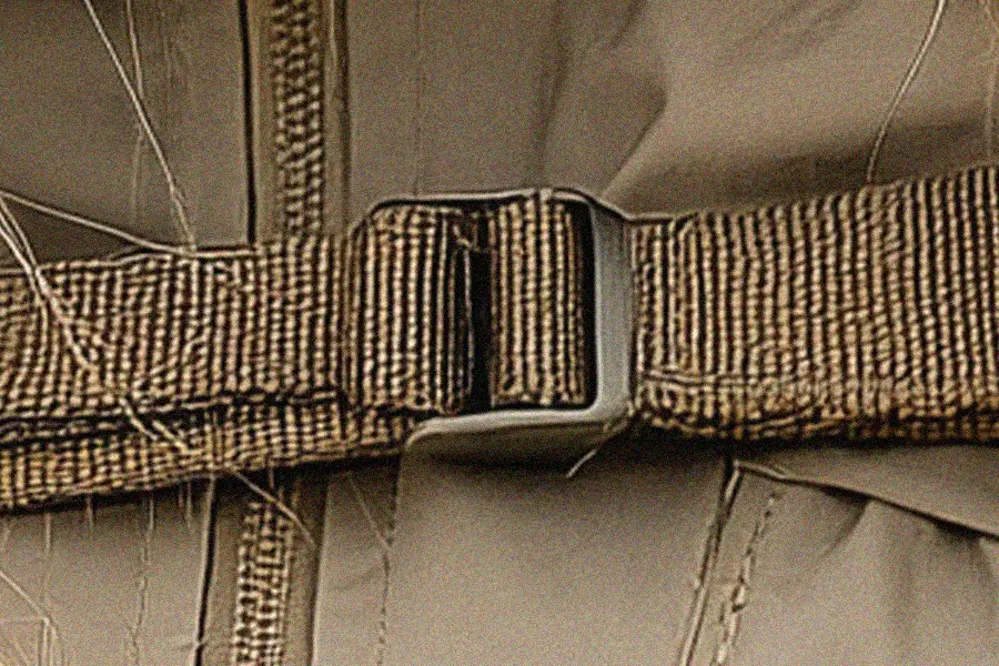 Close-up of an AI-generated jacket buckle and strap with unrealistic construction