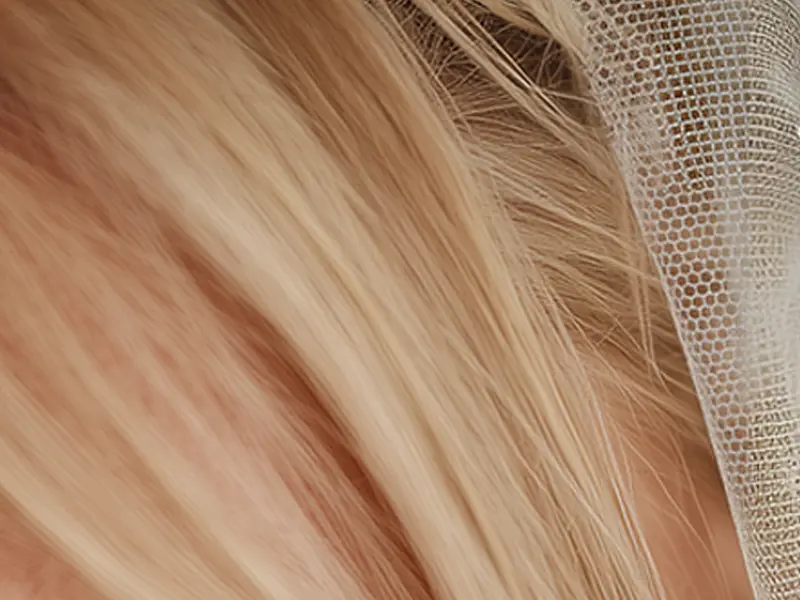 Close-up of a wedding veil where the mesh pattern shifts between different shapes. A subtle AI-generated fabric error.